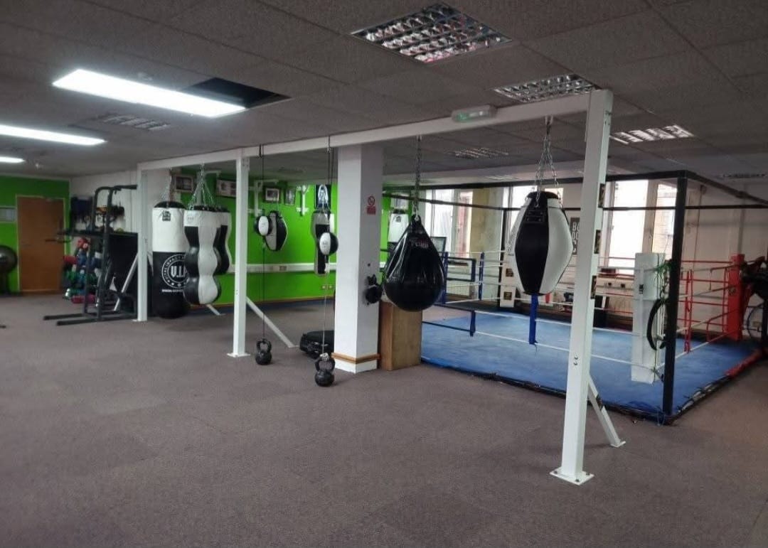 The boxing ring and hanging bags on the gym floor at Zestus Fitness.