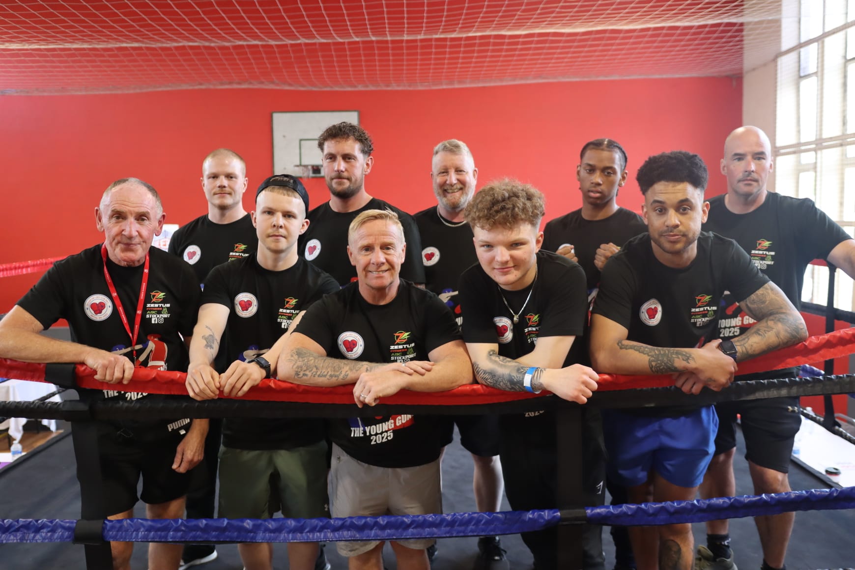 The Zestus ABC squad in club tees leaning on the ring ropes.